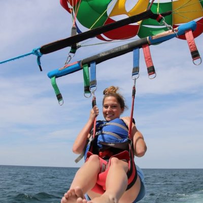 Parasailing Adventure Over Cape Cod Bay Guest enjoying a parasailing adventure over Cape Cod Bay with Dennis Parasail & Jet Ski, soaring above the ocean under a colorful parasail.
