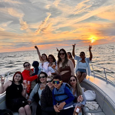 Private Sunset Cruise on Cape Cod Bay Group of friends and family enjoying a private sunset cruise on Cape Cod Bay, relaxing on a boat and watching a colorful sunset over the water.